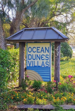 A sign for Ocean Dunes Villas with a beach-themed design.