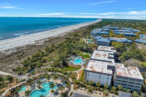 Een resort met meerdere gebouwen, een strand en een zwembadgedeelte.