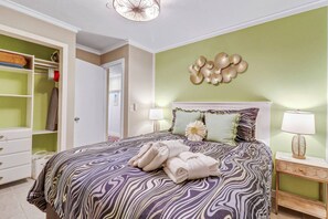 Een slaapkamer met een bed, nachtkastjes, een kledingkast en een decoratief wandobject.