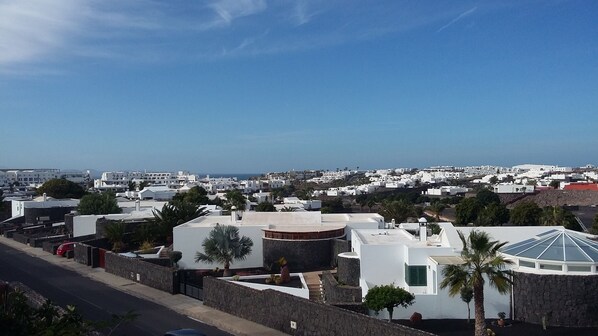 A coastal town with white buildings, a clear blue sky, and a view of the sea. - Dúpex in Playa Blanca (Playa Blanca)