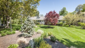 A well-maintained garden with a variety of plants and a large tree with red leaves. - Spacious & Gracious 3 Bedrooms, 2 Full Baths Ranch Living in central location!!! (Andover)