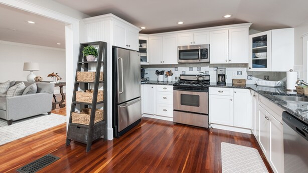 A modern kitchen with white cabinets, stainless steel appliances, and a wooden floor. - Spacious & Gracious 3 Bedrooms, 2 Full Baths Ranch Living in central location!!! (Andover)
