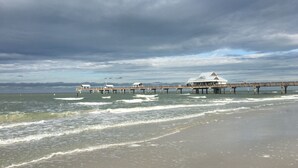 Une jetée s’avançant dans la mer, avec un bâtiment à son extrémité.