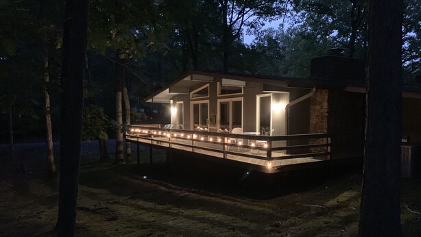 A modern cabin with a deck, large windows, and a stone exterior. - The Hideaway- Cozy Home in the Woods (Hot Springs)