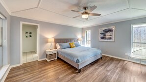 A bedroom with a bed, nightstands, a ceiling fan, and a window. - Near Highways, King bed, Family-friendly, Remote work, Foosball, Grill, Games (Carrollton)