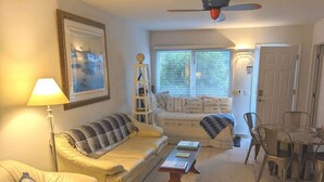 A living room with a sofa, a coffee table, and a dining area with chairs. - Sparkling Clean, Private & Quiet! Amazing Ocean Views [6] (Brookings)