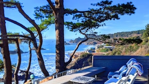 A deck with outdoor seating, overlooking a coastal landscape with trees and a view of the ocean. - Sparkling Clean, Private & Quiet! Amazing Ocean Views [6] (Brookings)