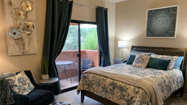 A bedroom with a bed, two chairs, a small table, and a potted plant. - Luxurious, Spacious Sedona Townhome-Spectacular Views/Minutes From Attractions! (Sedona)