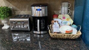 A kitchen counter with a toaster, a coffee maker, and a basket of food items. - Luxurious, Spacious Sedona Townhome-Spectacular Views/Minutes From Attractions! (Sedona)