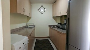 A compact kitchen with a stainless steel refrigerator, a coffee maker, and a toaster. - SM FIELD RESIDENCES, 85m2, FREE POOL, 2 BEDROOMS, 2 BATHROOMS, 24HRS SECURITY (Sucat)