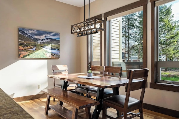 Dining with Large Windows Overlooking Tree-lined Backyard