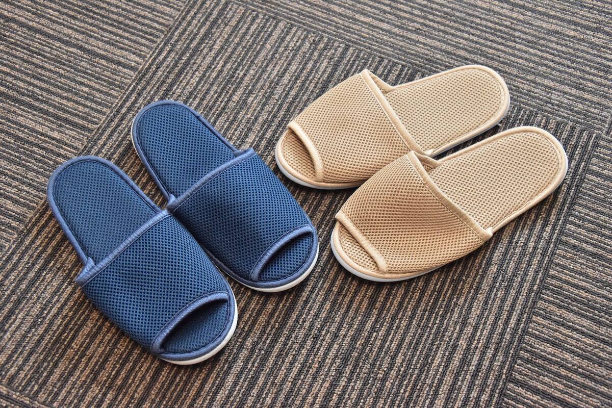 Un par de zapatillas azules y beige sobre una alfombra texturizada.