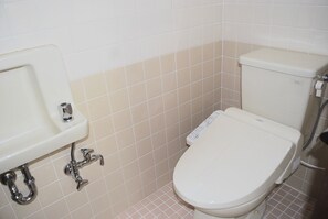 A bathroom with a white toilet, a sink, and a shower. - West Villa (Naha)