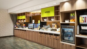 A breakfast area with a self-service station, a refrigerator with milk, and a sign indicating 'MORNING'. - Home2 Suites by Hilton Jacksonville Airport (Jacksonville)