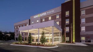 A modern hotel with a covered entrance, multiple floors, and a sign reading "HOME 2 SUITES BY HILTON". - Home2 Suites by Hilton Jacksonville Airport (Jacksonville)