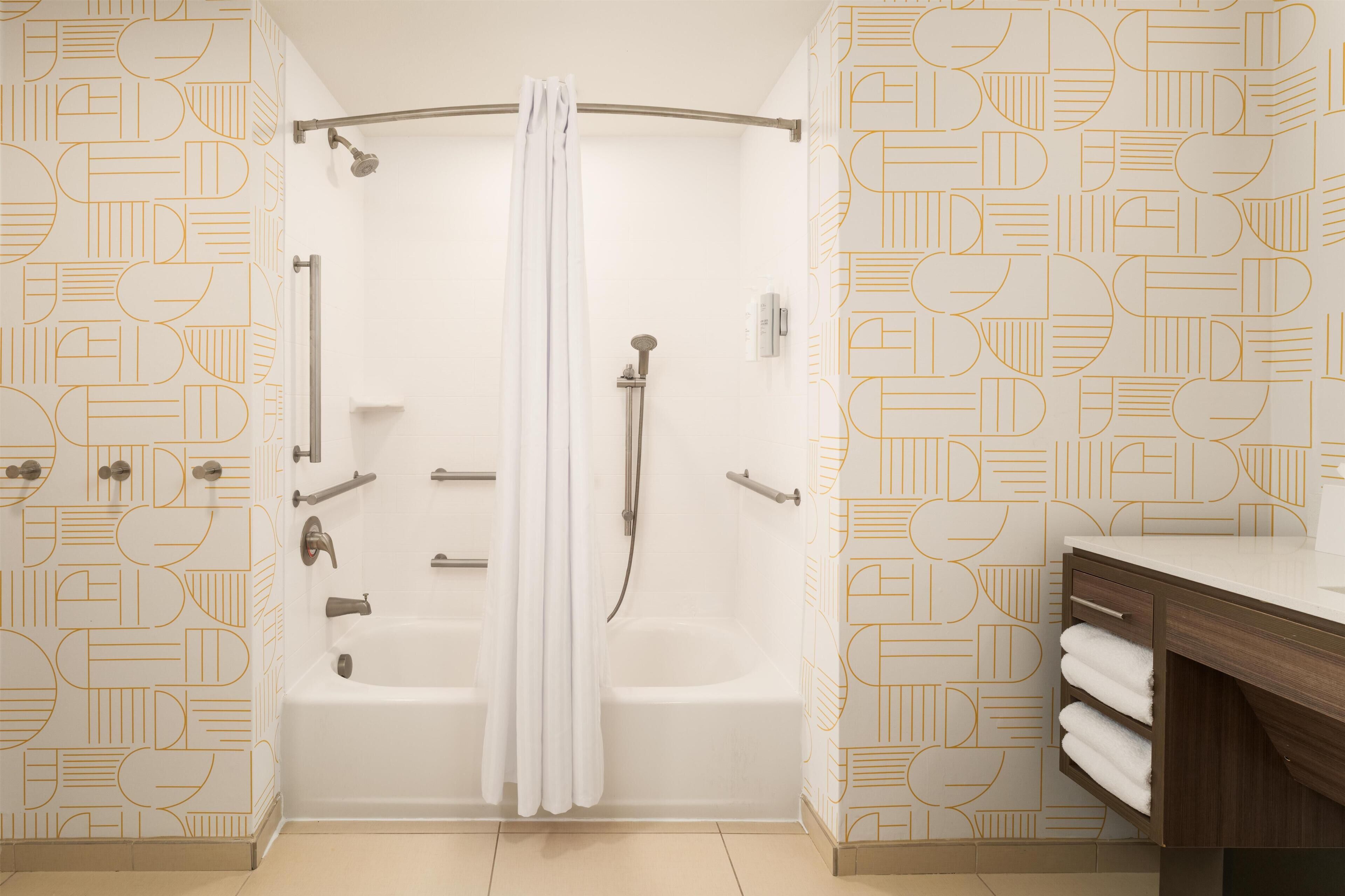 A modern bathroom with a shower, bathtub, and vanity.