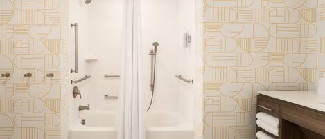 A modern bathroom with a shower, bathtub, and vanity.