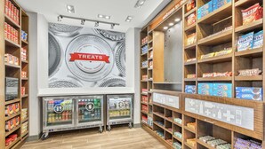 A snack and treat display area with refrigerated cases and shelves stocked with various snacks.