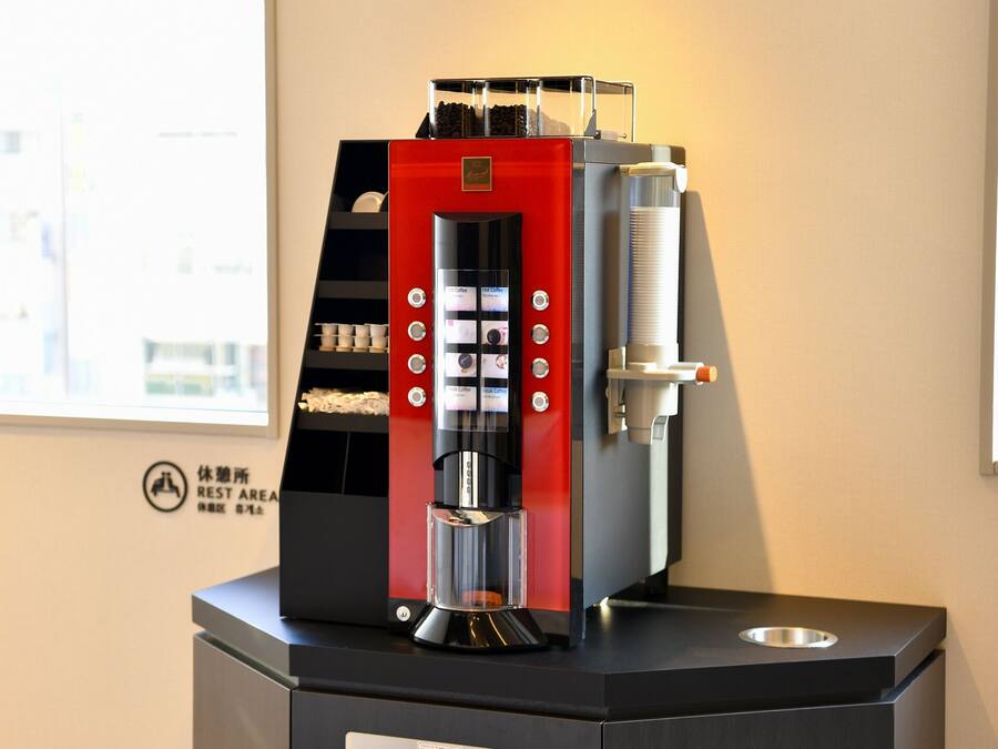 A coffee machine with a digital interface, a water reservoir, and a coffee cup holder.