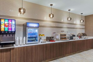 A self-service beverage station with a refrigerated drink dispenser and a coffee machine. - La Quinta Inn & Suites by Wyndham Kansas City Beacon Hill (Kansas City)