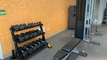 Een fitnessruimte met een bank en gewichten.