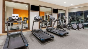 A gym with treadmills, elliptical machines, and stationary bikes.