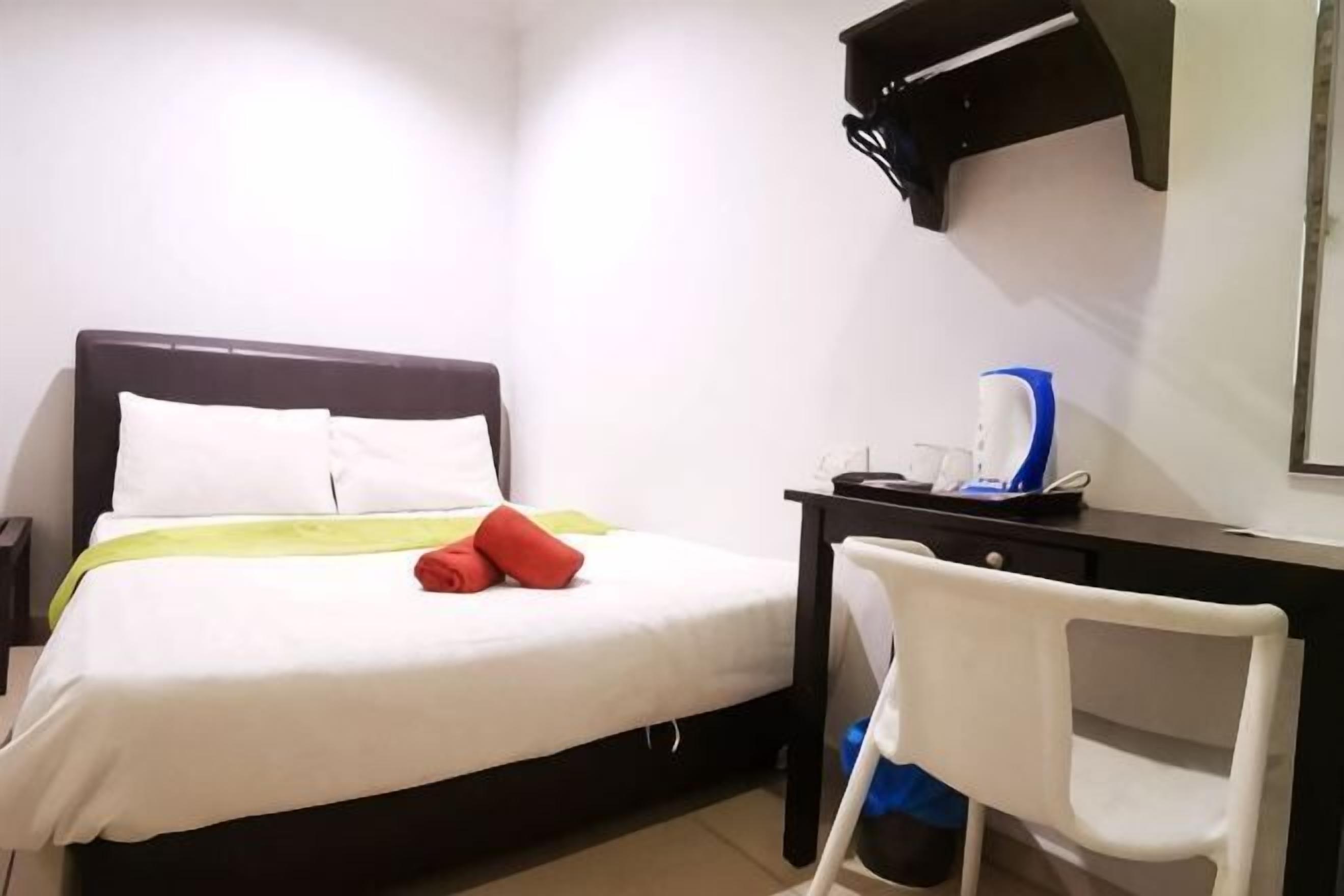 Une chambre d’hôtel comprenant un lit, un bureau avec une chaise, une machine à café et une petite table.