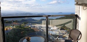 A balcony with a clear view of a parking area and distant mountains.