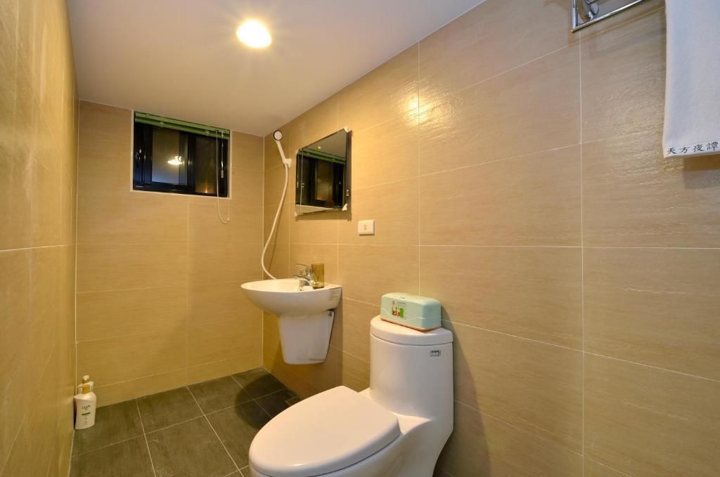 A bathroom with a toilet, sink, and shower.