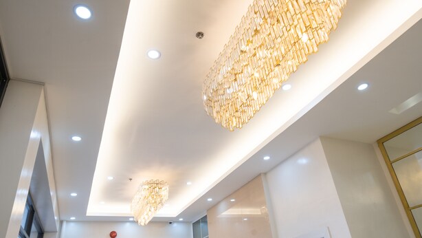 Un intérieur moderne avec un éclairage encastré et un grand lustre décoratif.