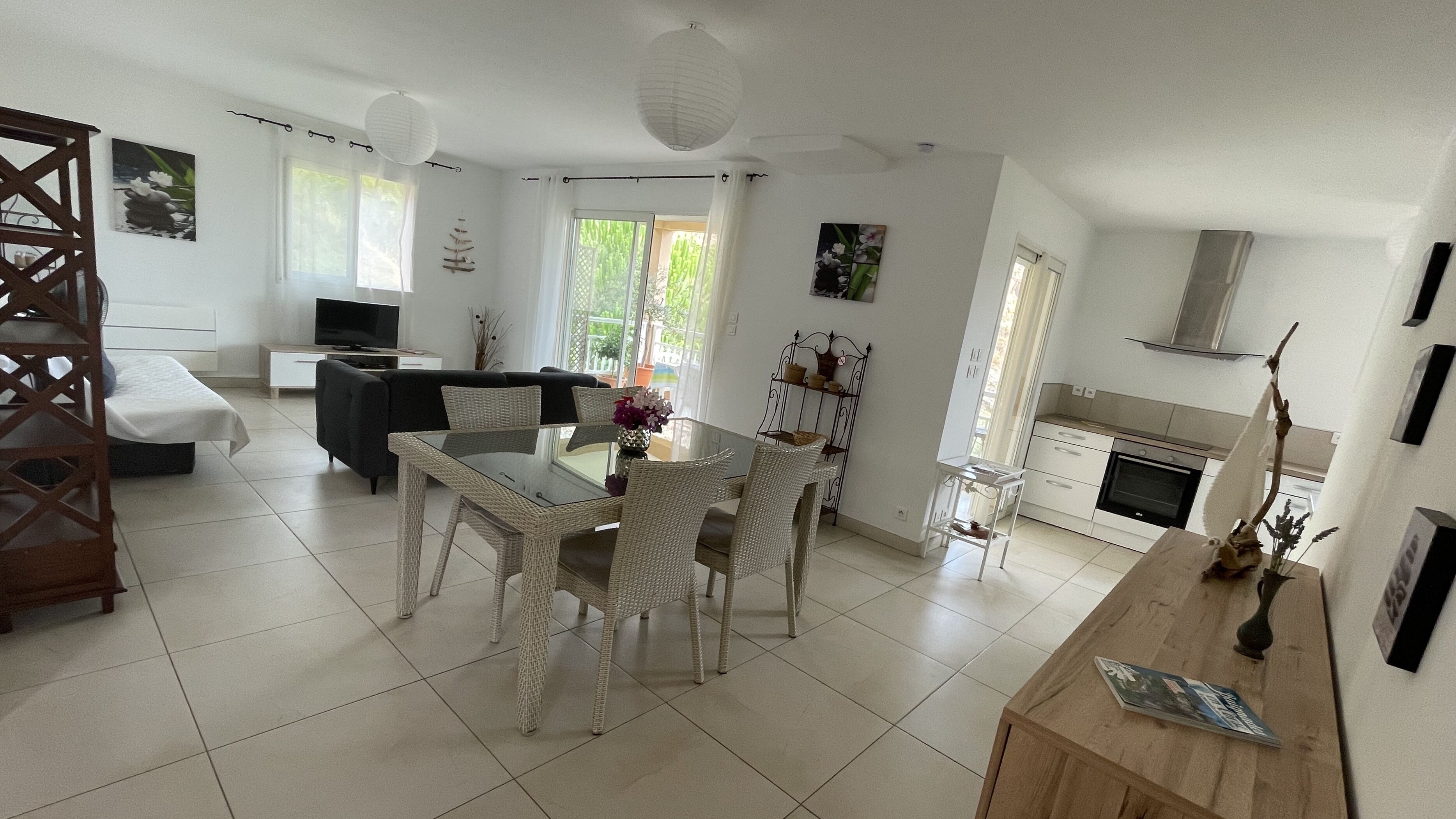 A spacious living area with a dining table, sofa, and kitchen.