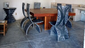 Un comedor con una mesa y sillas de madera, una mesita auxiliar y un cuadro colgado en la pared.