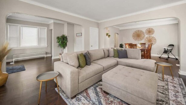 A spacious living room with a large L-shaped sectional sofa, a round coffee table, and a patterned rug. - Charming Home | Near Spokane City Center (Spokane)