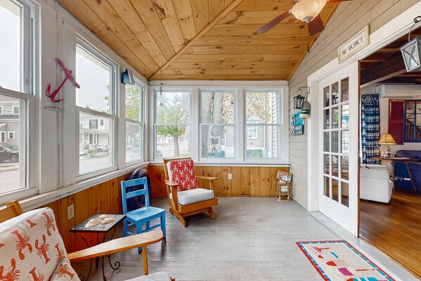 Relax in a welcoming space with a comfortable seating area, large windows, and a cozy atmosphere.