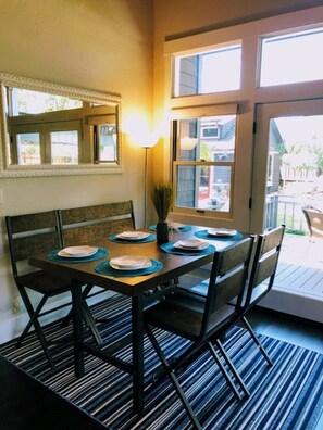 Enjoy meals in this dining area with a table for four, a decorative mirror, and a floor lamp.