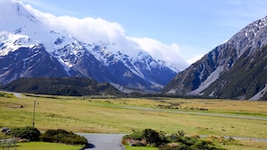 A mountainous landscape with a road and a small stream.