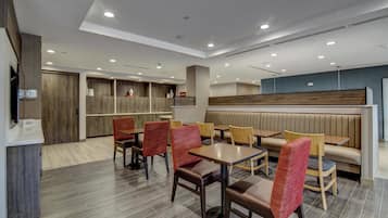 A modern restaurant with wooden paneling, booths, and a variety of seating options including tables and chairs.
