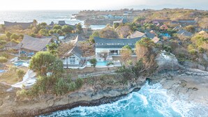 A coastal resort with a large pool, multiple buildings, and a view of the ocean. - Mandala The Bay (Lembongan Island)