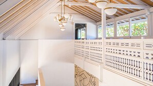 A spacious interior with a high ceiling, wooden beams, and a seating area with a sofa and coffee table. - Mandala The Bay (Lembongan Island)