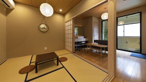 Une pièce de style japonais traditionnel, avec un sol recouvert de tatamis, une table basse et des portes coulissantes donnant sur un autre espace.