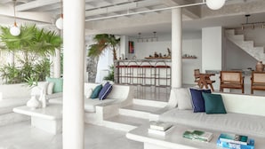 Ein modernes Interieur in Weiß mit einer Couch, einem Couchtisch und einer Treppe.