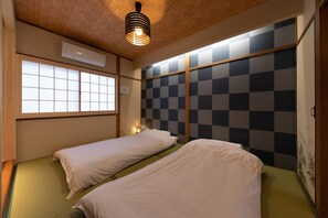 A room with two beds, a window, and a checkered wall. - Shirakabanoyado-Tennoji (Osaka)
