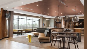 A spacious lobby with a modern design, featuring a large seating area, a bar, and a large window providing natural light. - SpringHill Suites by Marriott Texas City (Texas City)