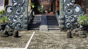 A staircase leading up to a building entrance with ornate metal railings and decorative stone carvings. - Hotel Bahtera PT.Pelni (Megamendung)
