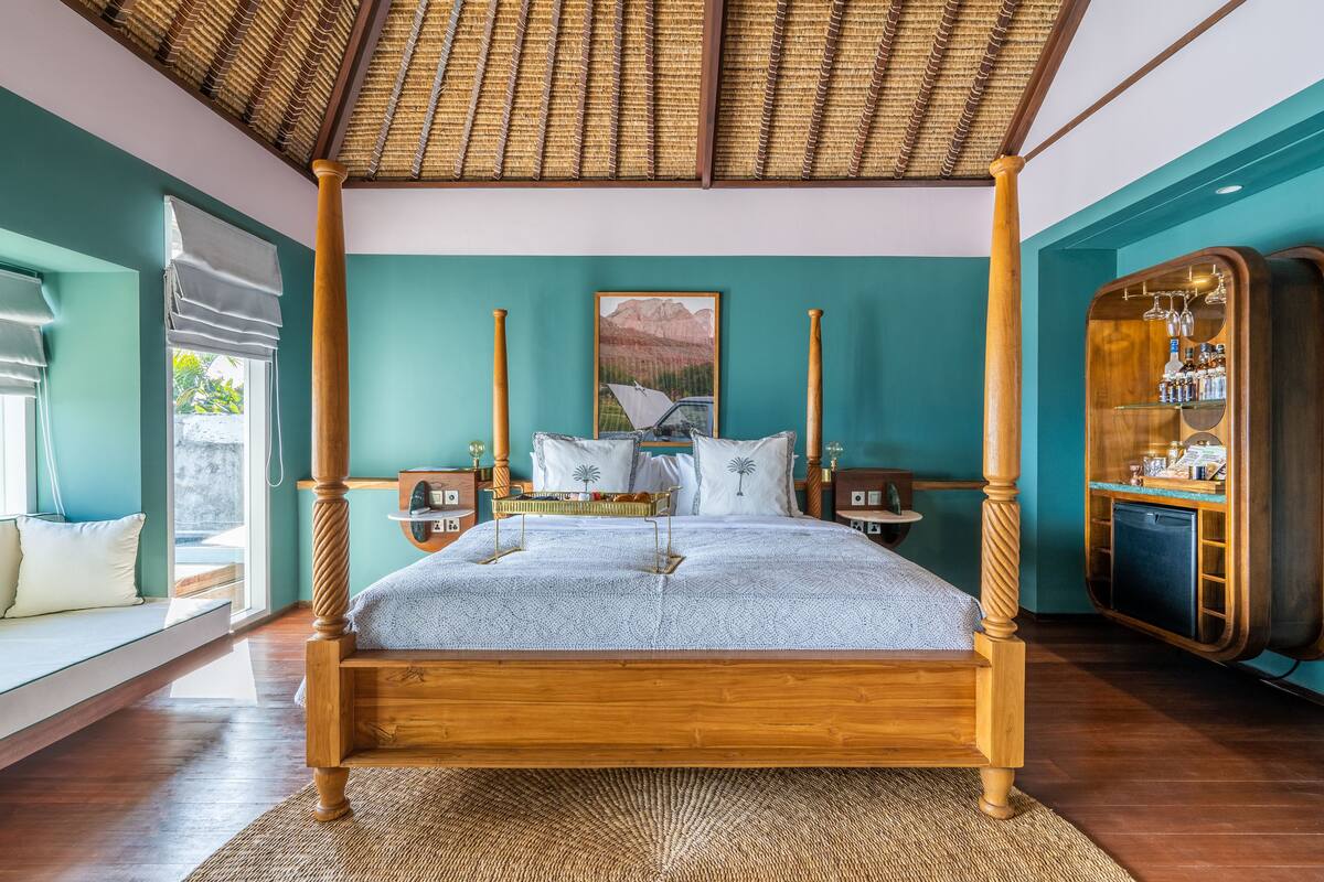 A four-poster bed with a wooden frame and a woven ceiling.