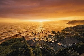 A coastal resort with beachfront villas, palm trees, and a sunset view. - Ulu Cliffhouse - Adult Only (Pecatu)