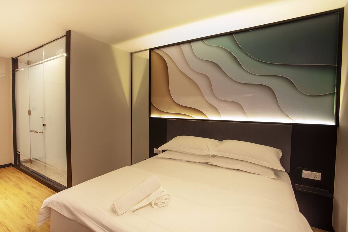 Ein Hotelzimmer mit Bett, Schrank und Wand mit Struktur.