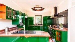 A kitchen with green cabinets, a wooden countertop, a sink, and a stove. - SPEERS POINT - Water Views, Pool, Sleeps 12, 8 Beds, Great for Families/groups (Speers Point)