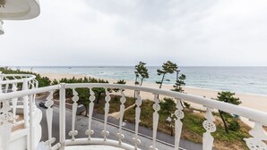 A balcony with a view of the beach and ocean. - Hotel Juno (Gangneung)