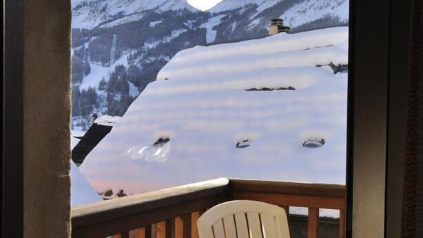 A wooden deck with a white Adirondack chair overlooking a snowy mountain landscape. - Hôtel de l'Europe et des Bains (Monetier-les-Bains)